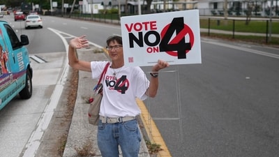 CORRECTS LANGUAGES TO MATCH AP STYLE - Anti-abortion Catholic Sonja Kahkonen waves to passing cars as she holds a "Vote No on 4" sign, urging voters to reject Amendment 4, which would enshrine abortion rights in the state, on Election Day, Tuesday, Nov. 5, 2024, outside a polling place at the Coliseum in St. Petersburg, Fla. (AP Photo/Rebecca Blackwell) (AP) CORRECTS LANGUAGES TO MATCH AP STYLE - Anti-abortion Catholic Sonja Kahkonen waves to passing cars as she holds a "Vote No on 4" sign, urging voters to reject Amendment 4, which would enshrine abortion rights in the state, on Election Day, Tuesday, Nov. 5, 2024, outside a polling place at the Coliseum in St. Petersburg, Fla. (AP Photo/Rebecca Blackwell) (AP)