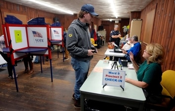 A voter, center, receives assistance from a poll worker before voting on Election Day in Waltham, US. (AP) A voter, center, receives assistance from a poll worker before voting on Election Day in Waltham, US. (AP)