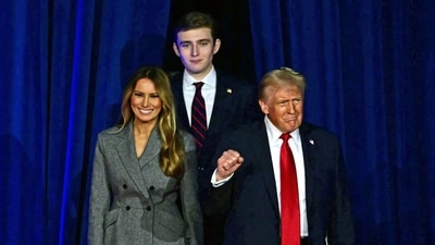 TOPSHOT - Former US President and Republican presidential candidate Donald Trump (R) arrives for  an election night event alongside former US First Lady Melania Trump and his son Barron Trump at the West Palm Beach Convention Center in West Palm Beach, Florida, on November 6, 2024. (Photo by Jim WATSON / AFP) (AFP)