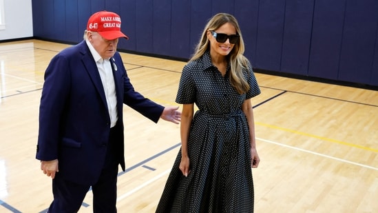 Republican presidential nominee former President Donald Trump escorts his wife Melania Trump at the polling place in the Morton and Barbara Mandel Recreation Center on Election Day, on November 05, 2024 in Palm Beach, Florida. (Getty Images via AFP)