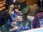 BJP MLAs pin down marshal after a brawl broke out over a banner on the restoration of Article 370 displayed by Awami Ittehad Party (AIP) MLA and brother of Lok Sabha MP Engineer Rashid, Khursheed Ahmad Sheikh in the Jammu and Kashmir Legislative Assembly session, in Srinagar on Thursday. 