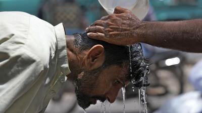A person pours water on another man to cool off during a hot day in Karachi, Pakistan in May this year. (AP Photo) A person pours water on another man to cool off during a hot day in Karachi, Pakistan in May this year. (AP Photo)