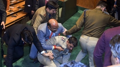 BJP MLAs pin down marshal after a brawl broke out over a banner on the restoration of Article 370 displayed by Awami Ittehad Party (AIP) MLA and brother of Lok Sabha MP Engineer Rashid, Khursheed Ahmad Sheikh in the Jammu and Kashmir Legislative Assembly session, in Srinagar on Thursday. (ANI) BJP MLAs pin down marshal after a brawl broke out over a banner on the restoration of Article 370 displayed by Awami Ittehad Party (AIP) MLA and brother of Lok Sabha MP Engineer Rashid, Khursheed Ahmad Sheikh in the Jammu and Kashmir Legislative Assembly session, in Srinagar on Thursday. (ANI)