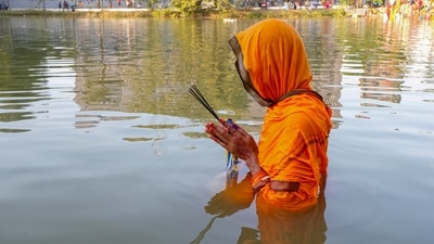 A devotee worships the setting sun during Chhath Puja festival, in Agartala. Devotees follow a 36-hour fast, frequently without water. (PTI) A devotee worships the setting sun during Chhath Puja festival, in Agartala. Devotees follow a 36-hour fast, frequently without water. (PTI)