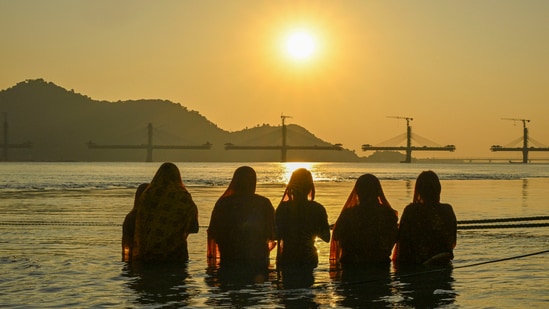 Devotees worship the setting sun during Chhath Puja, at the River Brahmaputra Ghat in Guwahati, It is celebrated six days after Diwali and lasts four days.(PTI)