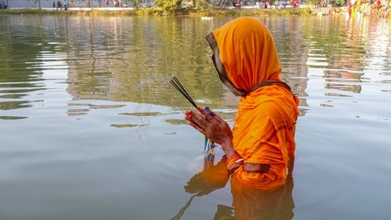 A devotee worships the setting sun during Chhath Puja festival, in Agartala. Devotees follow a 36-hour fast, frequently without water.(PTI)