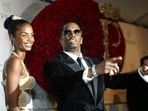 Sean "P. Diddy" Combs directs photographers as they sing "Happy Birthday," to him as his date Kim Porter, left, listens, after Combs arrived for his 35th birthday celebration at Cipriani on Wall Street in New York, Nov. 4, 2004. 