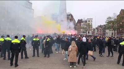 In this image taken from video, police stand guard as Maccabi Tel Aviv supporters light flares at the Dam square, in Amsterdam (AP Photo InterVision) (AP) In this image taken from video, police stand guard as Maccabi Tel Aviv supporters light flares at the Dam square, in Amsterdam (AP Photo InterVision) (AP)