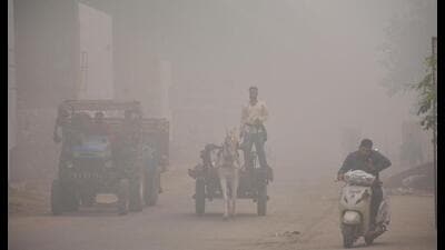 Commuters struggle to make their way amid smog in Amritsar on Saturday (HT Photo)