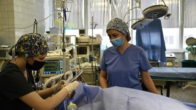 Medical staff at the septic surgery department of the Mechnikov Hospital in Dnipro check a patient on September 26, 2024, amid the Russian invasion of Ukraine. Direct combat and aerial strikes have triggered a rise in patients suffering from traumatic wounds, who have overwhelmed understaffed hospitals. The Dnipro Mechnikov Hospital saw its workload increase tenfold, said chief surgeon Sergiy Kosulnykov. (Photo by Genya SAVILOV / AFP) (AFP) Medical staff at the septic surgery department of the Mechnikov Hospital in Dnipro check a patient on September 26, 2024, amid the Russian invasion of Ukraine. Direct combat and aerial strikes have triggered a rise in patients suffering from traumatic wounds, who have overwhelmed understaffed hospitals. The Dnipro Mechnikov Hospital saw its workload increase tenfold, said chief surgeon Sergiy Kosulnykov. (Photo by Genya SAVILOV / AFP) (AFP)