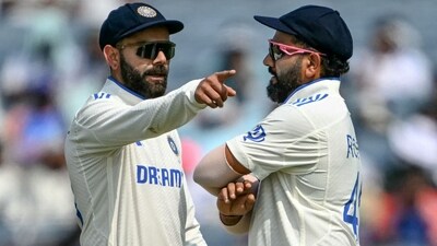 India's Virat Kohli talks with his captain Rohit Sharma (R) during Test match between India and New Zealand (AFP)