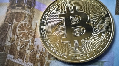 A souvenir bitcoin token is seen pictured with a 100 ruble bill in Moscow on July 30, 2024 (Alexander Nemenov/AFP) A souvenir bitcoin token is seen pictured with a 100 ruble bill in Moscow on July 30, 2024 (Alexander Nemenov/AFP)