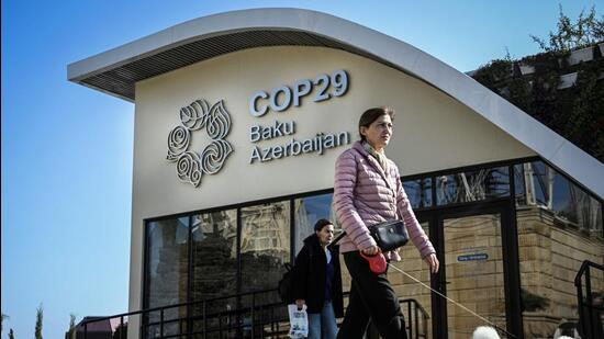 A pedestrian walks past a COP29 information centre in Baku, Azerbaijan, on Sunday. (AFP Photo)