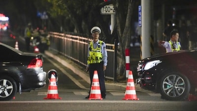 A security personnel stands guard near a sports center where a man rammed a car into people exercising in Zhuhai, China on Monday. (AP) A security personnel stands guard near a sports center where a man rammed a car into people exercising in Zhuhai, China on Monday. (AP)