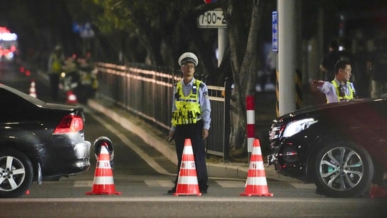 A security personnel stands guard near a sports center where a man rammed a car into people exercising in Zhuhai, China on Monday. (AP)