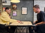 The image shows YouTubers MrBeast and Raj Shamani playing carrom and then recording a podcast. The image shows YouTubers MrBeast and Raj Shamani playing carrom and then recording a podcast.