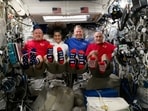 In this photo provided by NASA, from left, astronauts Butch Wilmore, Suni Williams, Nick Hague and Don Pettit show their U.S. flag-themed socks aboard the International Space Station on Election Day, Tuesday, Nov. 5, 2024.