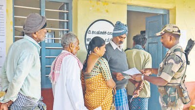A security personnel checks voter ID as voters wait to cast votes at a polling station during the Channapatna Assembly bypoll, Karnataka (PTI) A security personnel checks voter ID as voters wait to cast votes at a polling station during the Channapatna Assembly bypoll, Karnataka (PTI)