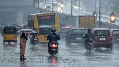 Commuters ride along a street amid rainfall in Chennai on November 12, 2024. (AFP) Commuters ride along a street amid rainfall in Chennai on November 12, 2024. (AFP)