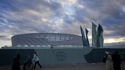 People walk outside the Baku Olympic Stadium, the venue for the COP29 UN Climate Summit, on Wednesday, in Baku, Azerbaijan. (AP)