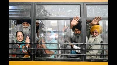 Pilgrims wave from a bus before departing for Pakistan to participate in the celebrations, marking the birth anniversary of Guru Nanak Dev, in Amritsar on Thursday. (AFP)
