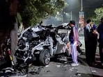 People gather around the car that got mangled after it hit a container, in Dehradun on Monday. People gather around the car that got mangled after it hit a container, in Dehradun on Monday.