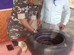 Security personnel removing stacks of cash from a tyre in Jharkhand. (Screengrab)