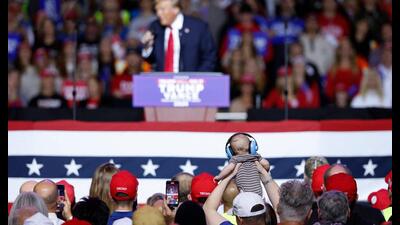 A supporter in the crowd holds up a baby wearing headphones as Donald Trump speaks at a campaign rally at the Fiserv Forum in Milwaukee, Wisconsin, November 1, 2024. (Photo by KAMIL KRZACZYNSKI / AFP) (AFP) A supporter in the crowd holds up a baby wearing headphones as Donald Trump speaks at a campaign rally at the Fiserv Forum in Milwaukee, Wisconsin, November 1, 2024. (Photo by KAMIL KRZACZYNSKI / AFP) (AFP)