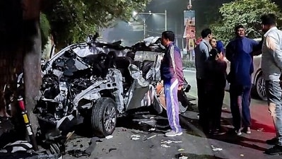People gather around the car that got mangled after it got hit by a container, in Dehradun on Monday. At least six people were killed and one other was injured in the accident. (ANI Photo) (ANI) People gather around the car that got mangled after it got hit by a container, in Dehradun on Monday. At least six people were killed and one other was injured in the accident. (ANI Photo) (ANI)