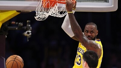LeBron James #23 of the Los Angeles Lakers dunks the ball in front of Zach Edey #14 of the Memphis Grizzlies during the fourth quarter at Crypto.com Arena on November 13, 2024 in Los Angeles, California. (Getty Images via AFP / Harry How)