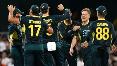 Australia's Nathan Ellis celebrates the wicket of Pakistan's Babar Azam with teammates Darren England/AAP Image via REUTERS (via REUTERS)