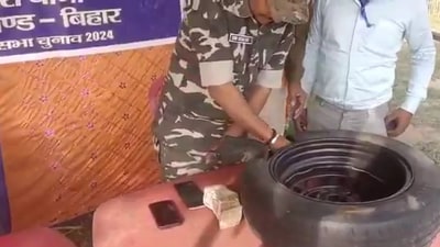 Security personnel removing stacks of cash from a tyre in Jharkhand. (Screengrab) Security personnel removing stacks of cash from a tyre in Jharkhand. (Screengrab)