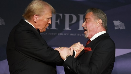 U.S. President-elect Donald Trump greets actor Sylvester Stallone onstage at the America First Policy Institute Gala held at Mar-a-Lago on November 14, 2024 in Palm Beach, Florida. (Getty Images via AFP)