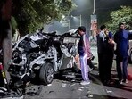 People gather around the car that got mangled after it hit a container, in Dehradun on Monday. People gather around the car that got mangled after it hit a container, in Dehradun on Monday.