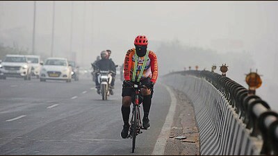 A cyclist braves the smog on National Highway-48 near Iffco Chowk elevated flyover in Gurugram on Saturday. (Parveen Kumar/HT)