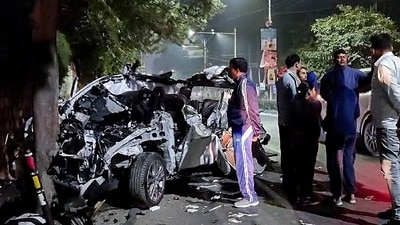 People gather around the car that got mangled after it hit a container, in Dehradun on Monday. (ANI) People gather around the car that got mangled after it hit a container, in Dehradun on Monday. (ANI)