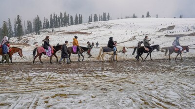 Gulmarg: Tourists take a pony ride after the season's first snowfall (PTI)