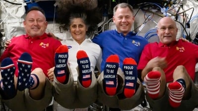 In this photo provided by NASA, from left, astronauts Butch Wilmore, Suni Williams, Nick Hague and Don Pettit show their U.S. flag-themed socks aboard the International Space Station on Election Day, Tuesday, Nov. 5, 2024. (AP) In this photo provided by NASA, from left, astronauts Butch Wilmore, Suni Williams, Nick Hague and Don Pettit show their U.S. flag-themed socks aboard the International Space Station on Election Day, Tuesday, Nov. 5, 2024. (AP)