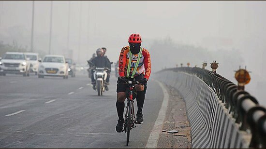 A cyclist braves the smog on National Highway-48 near Iffco Chowk elevated flyover in Gurugram on Saturday. (Parveen Kumar/HT)