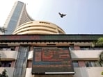 A bird flies past a screen displaying the Sensex results on the facade of the Bombay Stock Exchange (BSE) building in Mumbai.