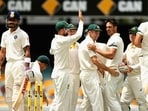 Mitchell Johnson celebrates as Virat Kohli looks on. 