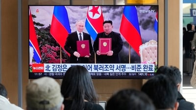 A TV screen shows a file image of North Korean leader Kim Jong Un, right, and Russian President Vladimir Putin in Pyongyang, during a news program at the Seoul Railway Station in Seoul, South Korea, Tuesday, Nov. 12, 2024. (AP Photo/Ahn Young-joon)