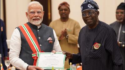 Prime Minister Narendra Modi (L) holds a certificate of Grand Commander of the Order of the Niger (GCON) as he poses for a photograph with Nigeria's President Bola Tinubu at the Presidential Palace in Abuja on Sunday. (AFP)
