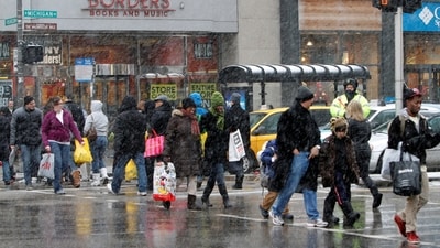 FILE PHOTO: Holiday shoppers carry their packages, as they walk down Michigan Avenue, during heavy snowfall, in Chicago December 24, 2010. REUTERS/Frank Polich/File Photo (REUTERS)