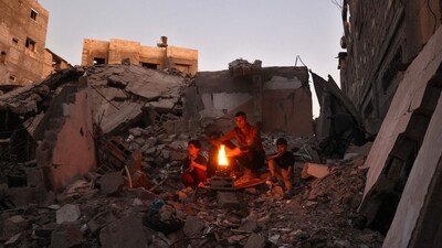 TOPSHOT - Palestinians warm by the fire in the rubble of destroyed buildings in the Bureij refugee camp in the central Gaza Strip on November 16, 2024, amid the ongoing war between Israel and the Hamas militant group. (Photo by Eyad BABA / AFP) (AFP) TOPSHOT - Palestinians warm by the fire in the rubble of destroyed buildings in the Bureij refugee camp in the central Gaza Strip on November 16, 2024, amid the ongoing war between Israel and the Hamas militant group. (Photo by Eyad BABA / AFP) (AFP)