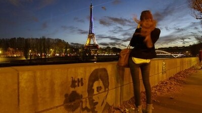 A girl takes a picture from the banks of the River Seine of the illuminated Eiffel Tower in the French national colours red, white and blue in honour of the victims of the terrorist attacks in Paris. (AP Photo) A girl takes a picture from the banks of the River Seine of the illuminated Eiffel Tower in the French national colours red, white and blue in honour of the victims of the terrorist attacks in Paris. (AP Photo)