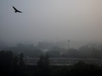 Traffic passes by on a road as the sky is enveloped with smog in New Delhi.