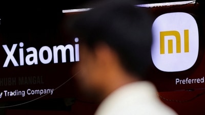 A man walks past a logo of Xiaomi, a Chinese manufacturer of consumer electronics, outside a shop in Mumbai, (Reuters)