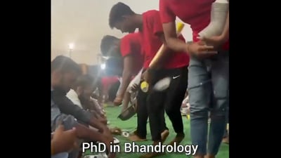 In the video, posted on X, four men serve cutlery to a long row of people sitting on the floor, waiting to be served food. (X/@terakyalenadena) In the video, posted on X, four men serve cutlery to a long row of people sitting on the floor, waiting to be served food. (X/@terakyalenadena)