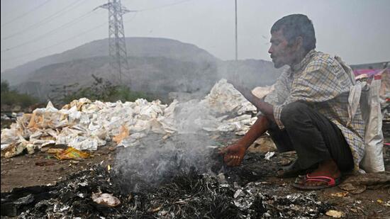 A man burns waste near Ghazipur landfill to keep himself warm in the early hours of Tuesday. (AFP)